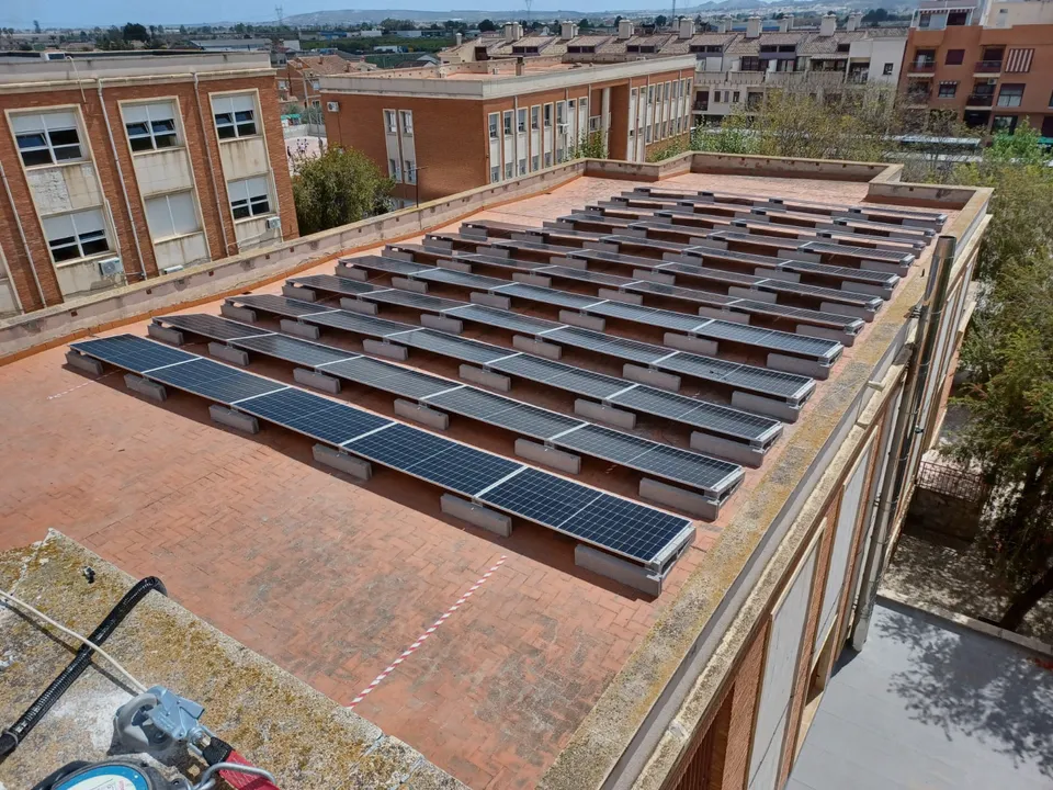 Paneles solares fotovoltaicos en la cubierta de un instituto 