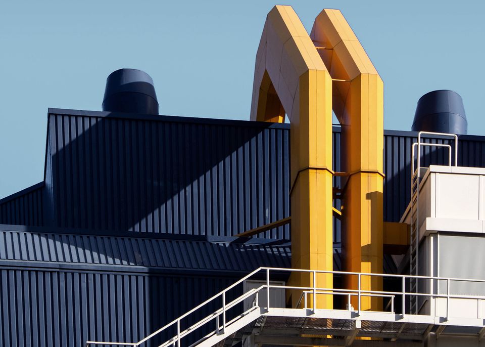 Industria moderna con dos tubos amarillos en una fachada azul